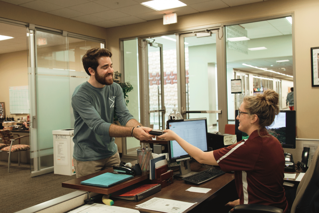 Male student receives his lost wallet from the MSC Student worker.