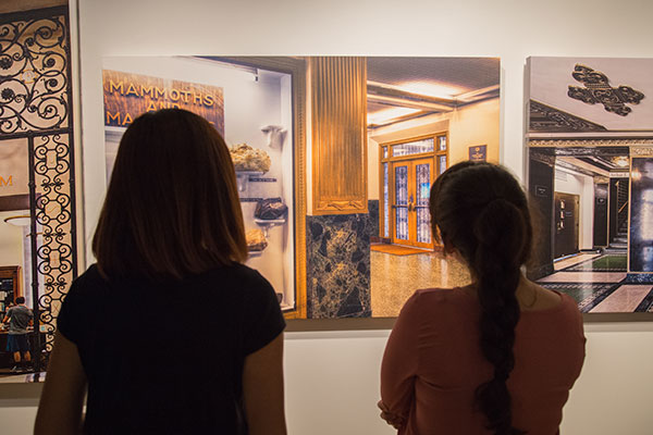 Two students looking at artwork hung in the Reynolds Gallery during an exhibit hosted by MSC VAC.